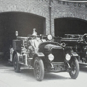 B&W fire-truck parked in front of open garage doors